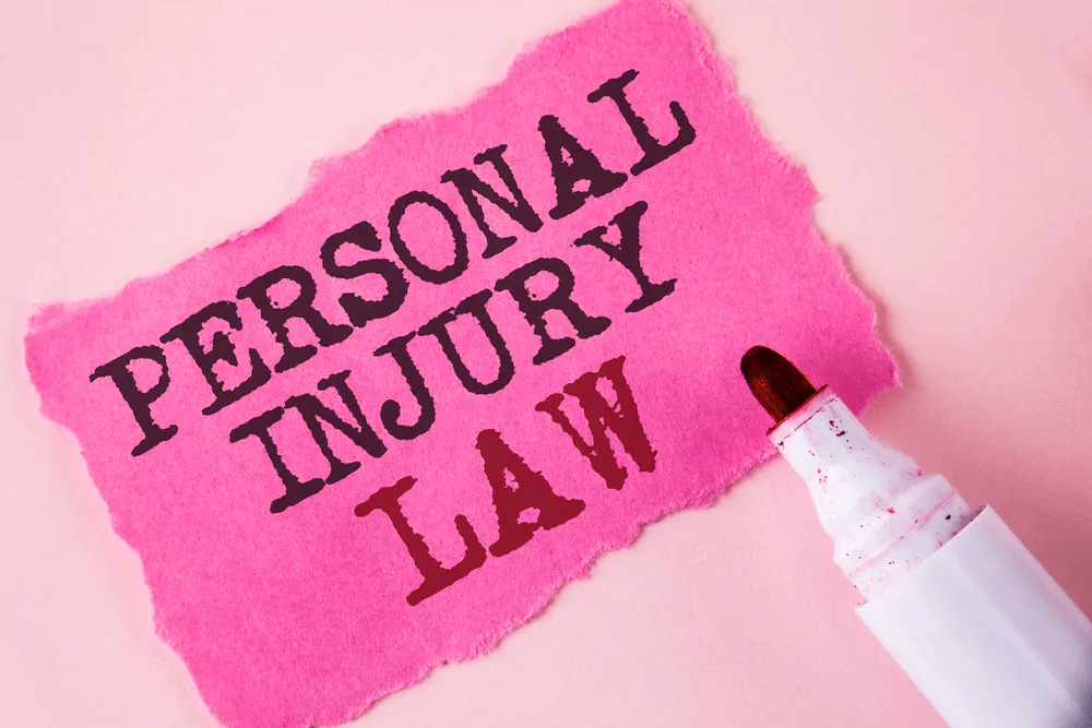 pink paper with the words "personal injury law" typed on it with a marker.