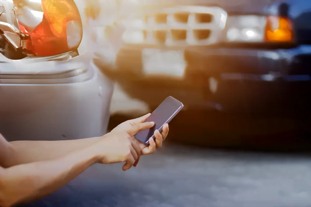 Cell phone being used to call someone and a car accident in the back round.