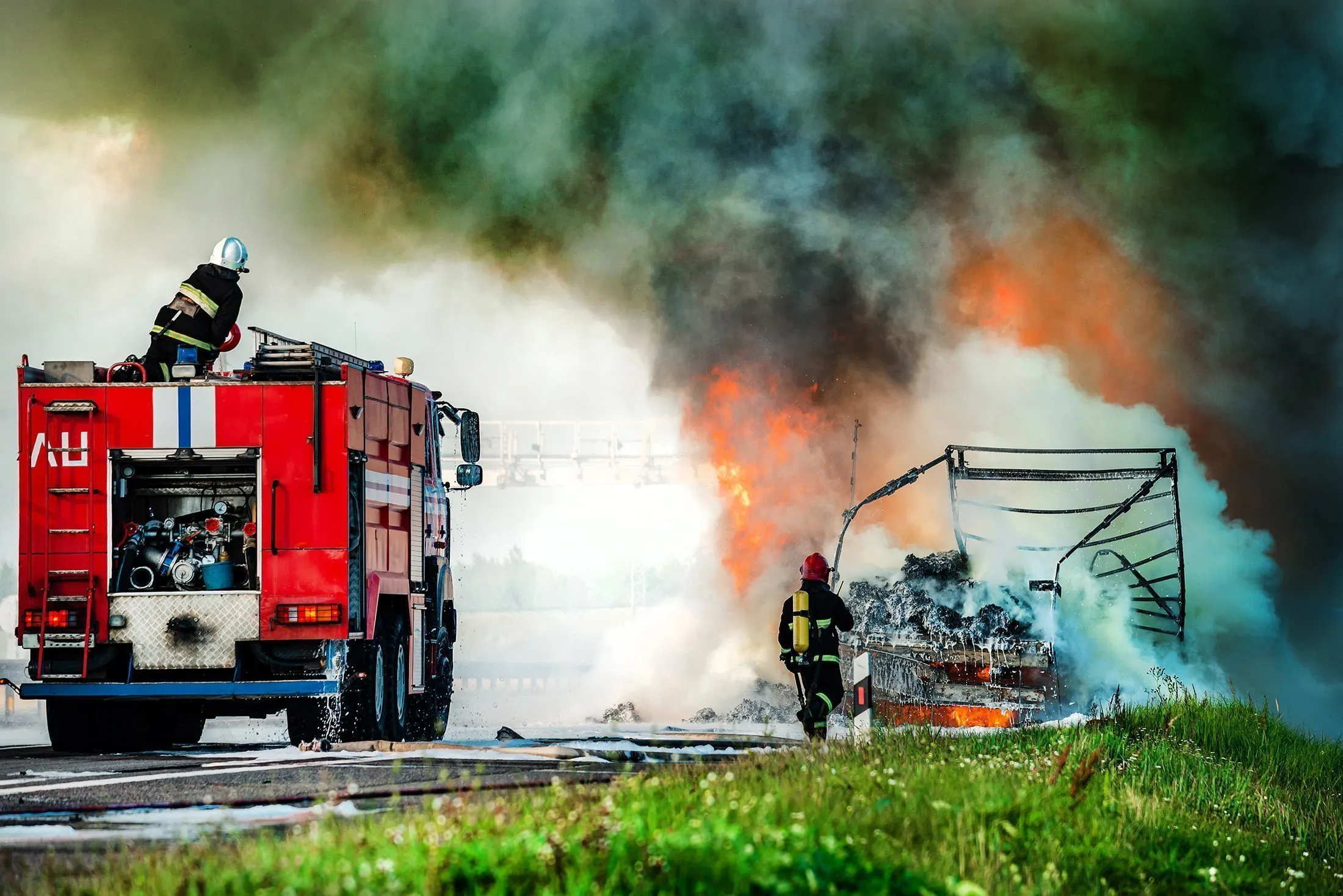 Firetruck and firemen putting out semi-truck on fire. If you’ve been injured by a commercial vehicle in Wyoming, our truck accident lawyers are ready to fight for you.