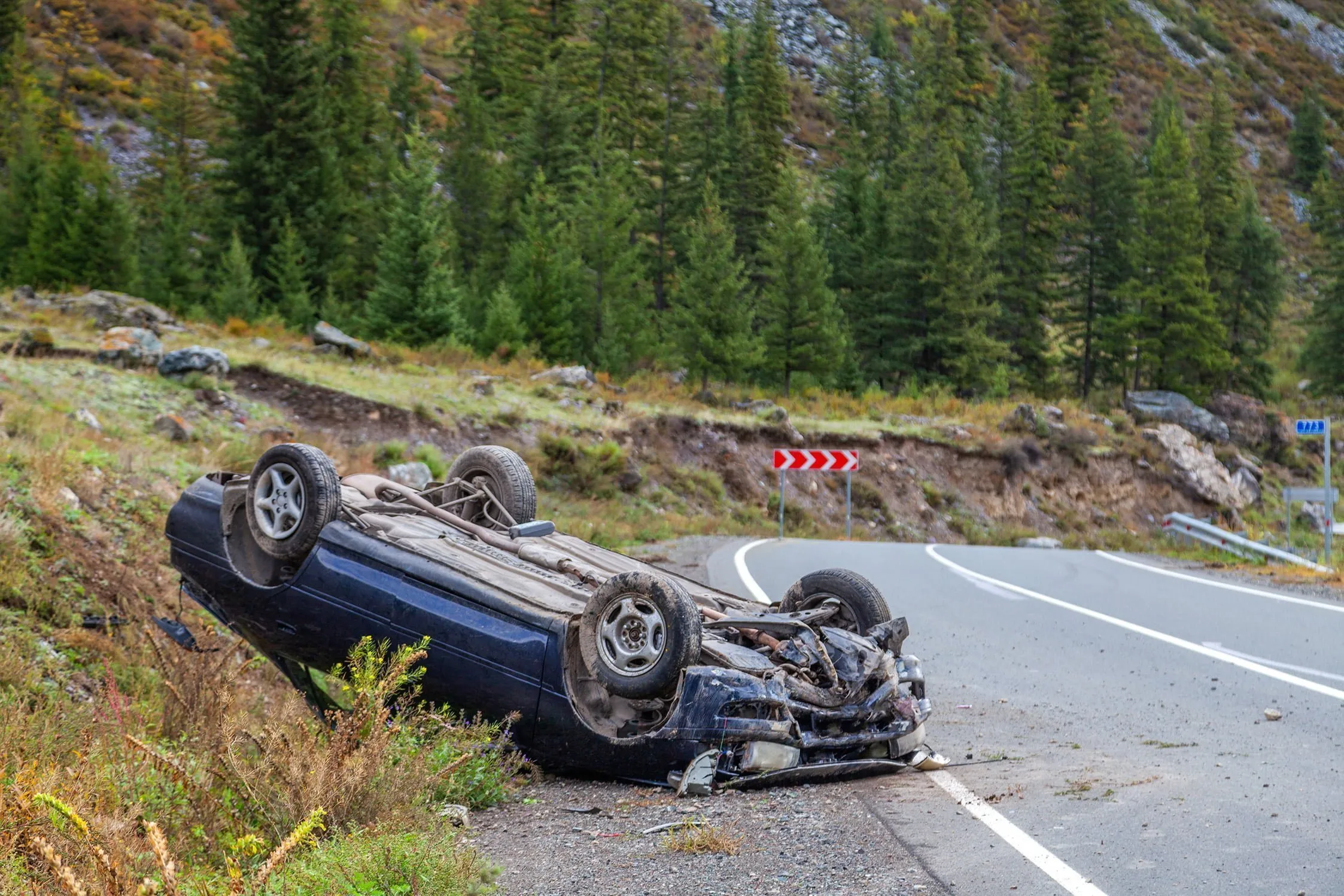 Car flipped upside down on the side of the road in the forest. If you’ve sustained an injury in a car accident, our Jackson car accident lawyers can help you get the compensation you deserve.