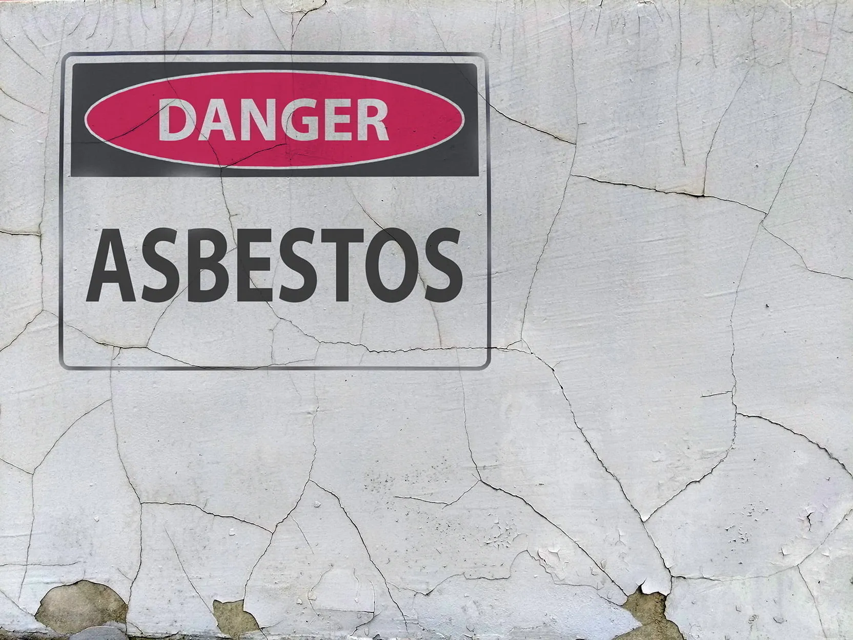 Sign on a cracked plaster wall reading “Danger: Asbestos”. If you or a loved one have been diagnosed with mesothelioma, our Wyoming mesothelioma attorneys are ready to fight for you.