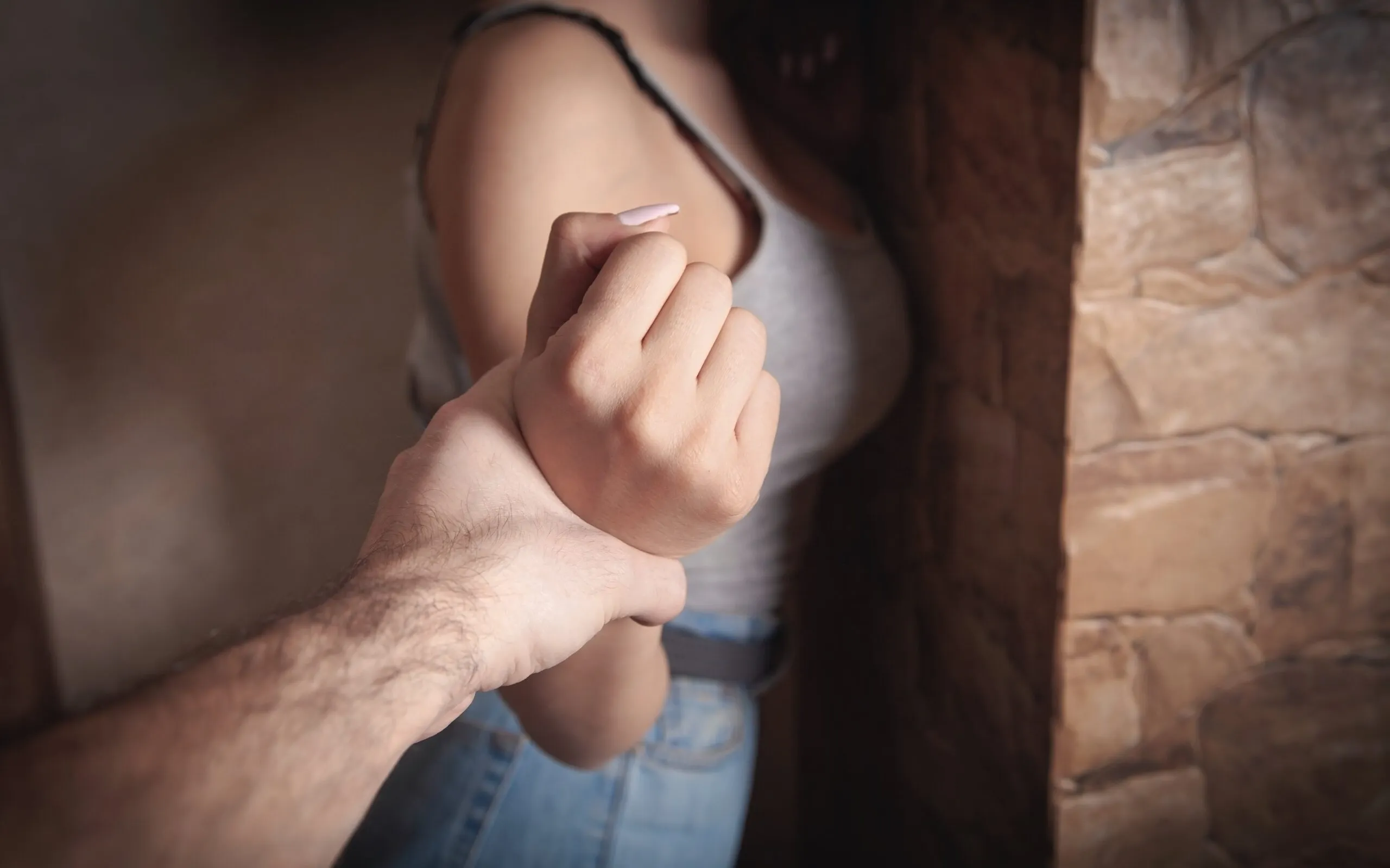 Angry male hand holding a woman’s wrist. Contact us for a sexual abuse lawyer that understand your rights and will fight for you.