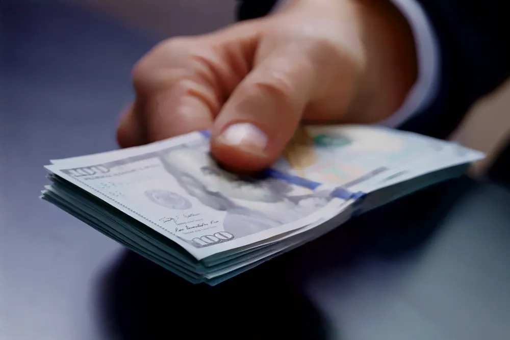 close up of a hand holding a stack of money,