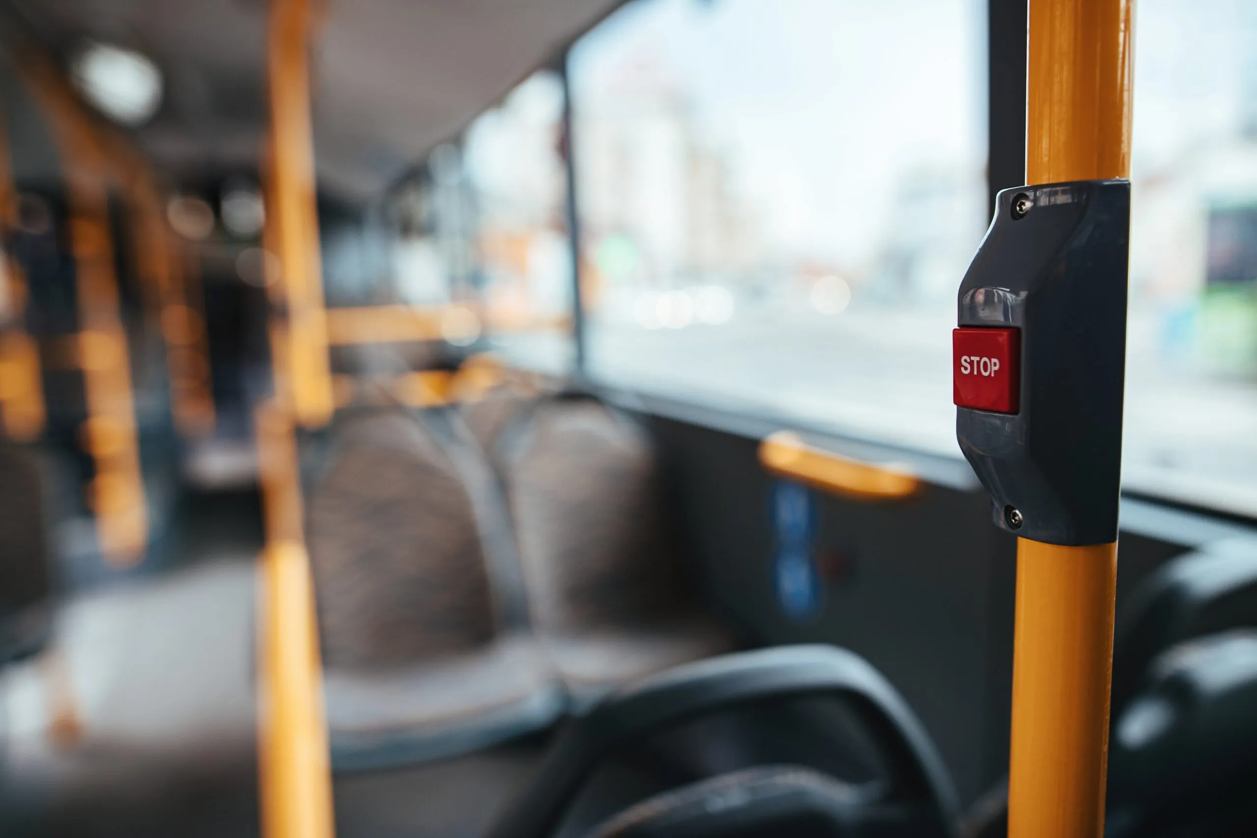 Picture of empty bus interior focuses on stop button. Get compensation for injuries incurred from a bus accident and call our Wyoming bus accident attorney today.