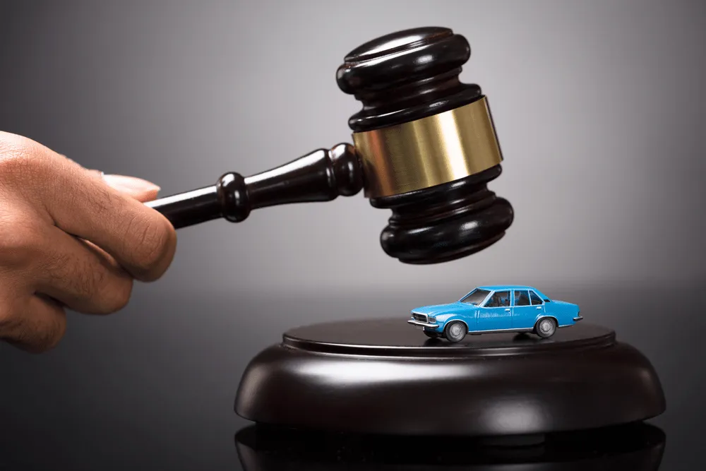 gavel about to smash a toy car.