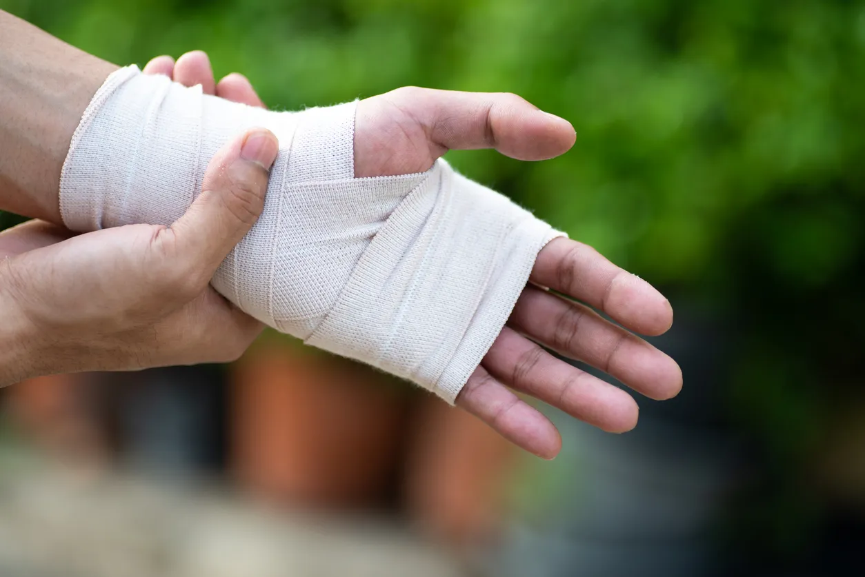 Injured hand wrapped in a bandage. 