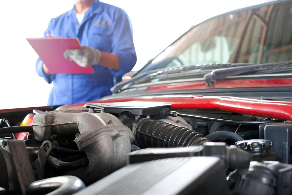 An inspector looking over a car for defects.